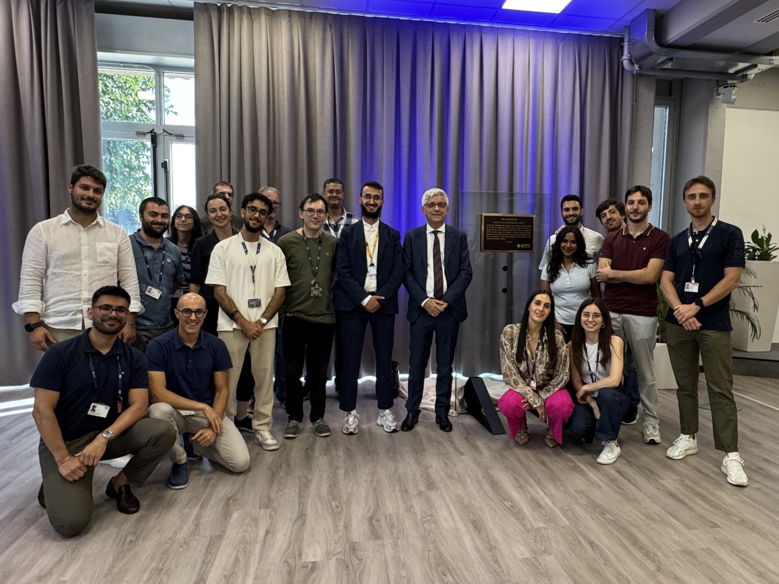Alessandro Cremonesi (ST Chief Innovation Officer) with young ST employees standing next to the IEEE plaque