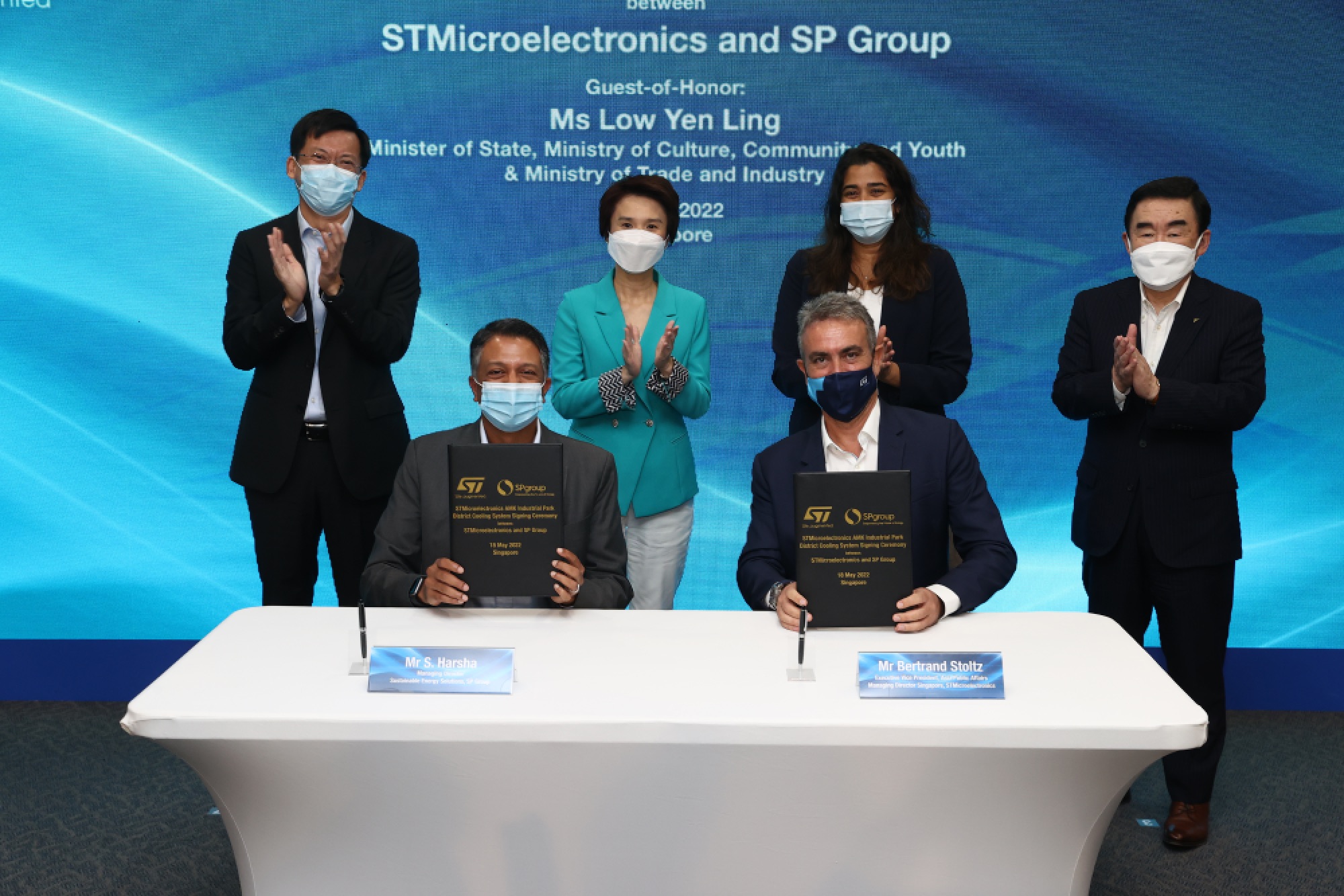 Signatories to the agreement at the table, from left: S. Harsha (SP Group) and Bertrand Stoltz (ST). Witnesses standing behind, from left: Stanley Huang, Group CEO (SP Group), Ms Low Yen Ling, Minister of State, Ministry of Culture, Community and Youth & Ministry of Trade and Industry, Ms Rajita D'Souza, President, HR and CSR (ST), Yoshihiro Mineno, Member of the board & Senior Executive Officer (Daikin)
