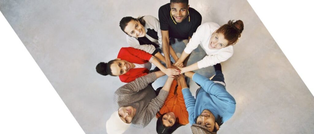 Multi ethnic group putting their hands together