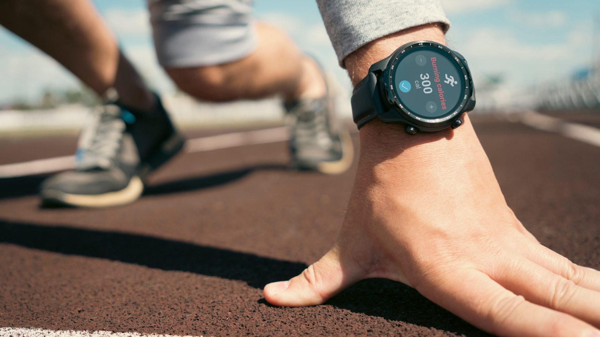 Man preparing to start on treadmill with smartwatch