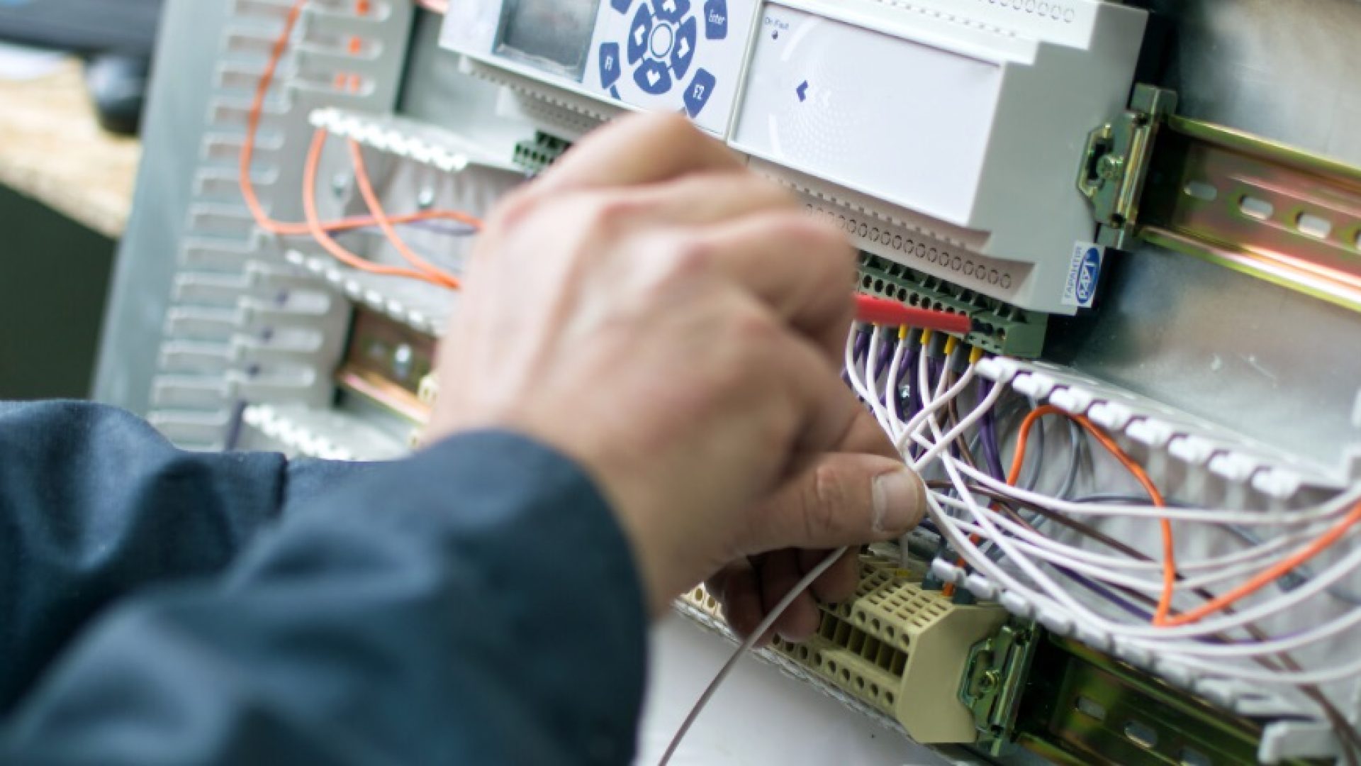 Electrician assembling industrial control cubicle in workshop. Close-up photo.; Shutterstock ID 767610436; purchase_order: 1106262587; job: ; client: ; other: