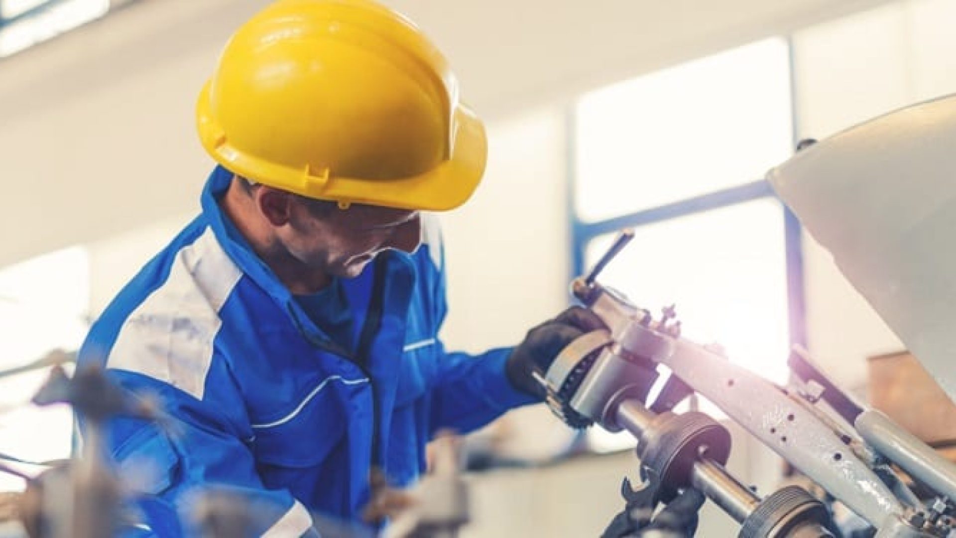 Blue collar worker or engineer working in industrial production plant, dealing with metal processing, hydraulic machinery, production lines and other pprocessing industry machines. Image taken in Serbia, Europe.