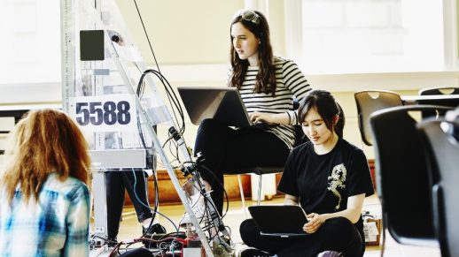 Female high school robotics team preparing robot for competition