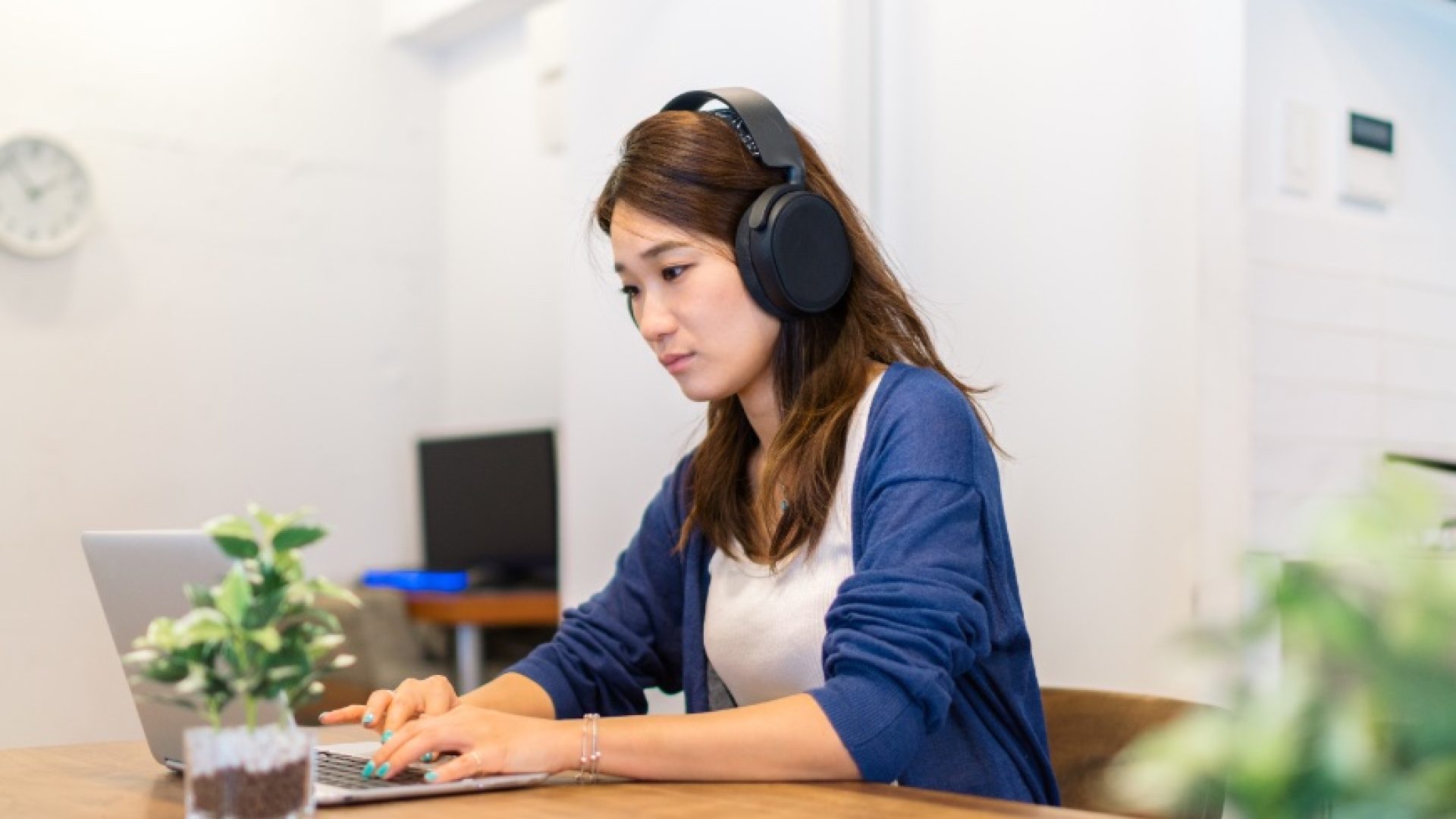 A young woman is working on a laptop at home.