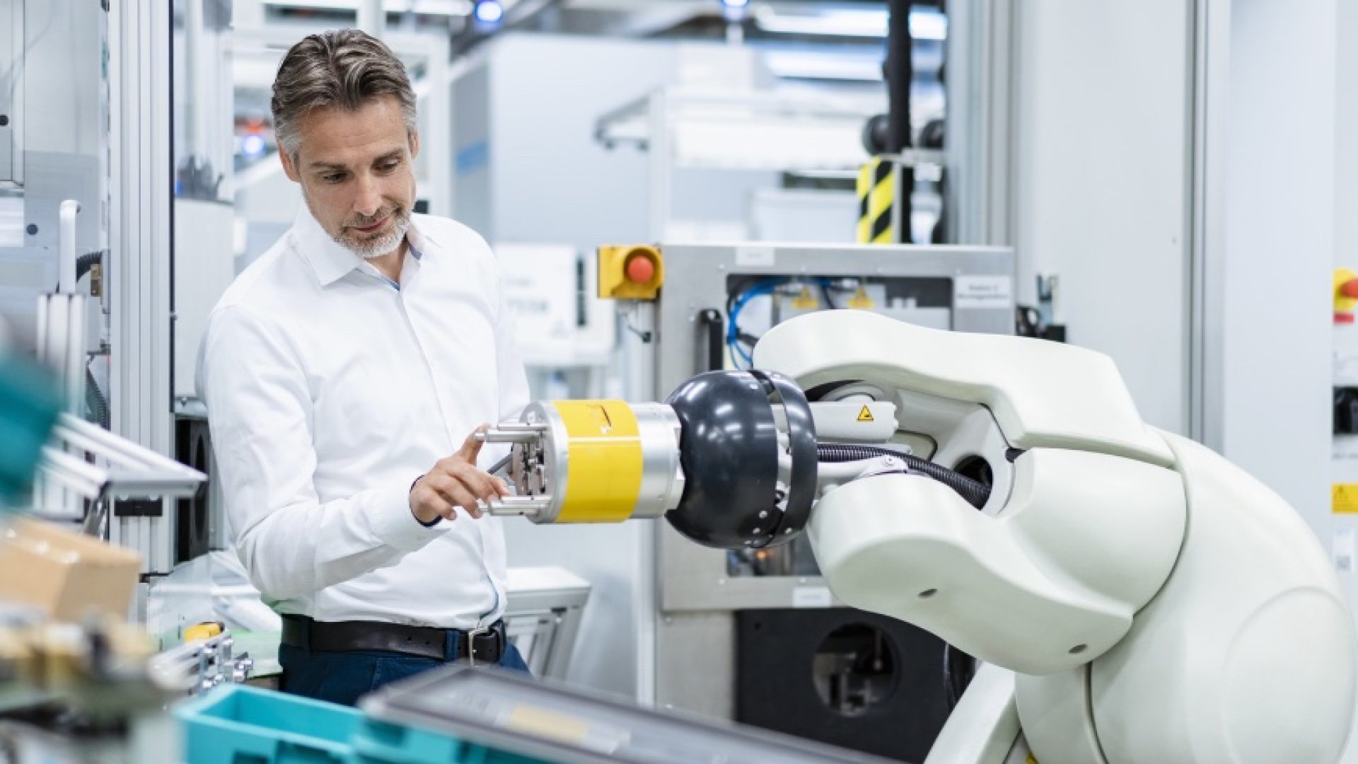 Businessman examining assembly robot in a factory