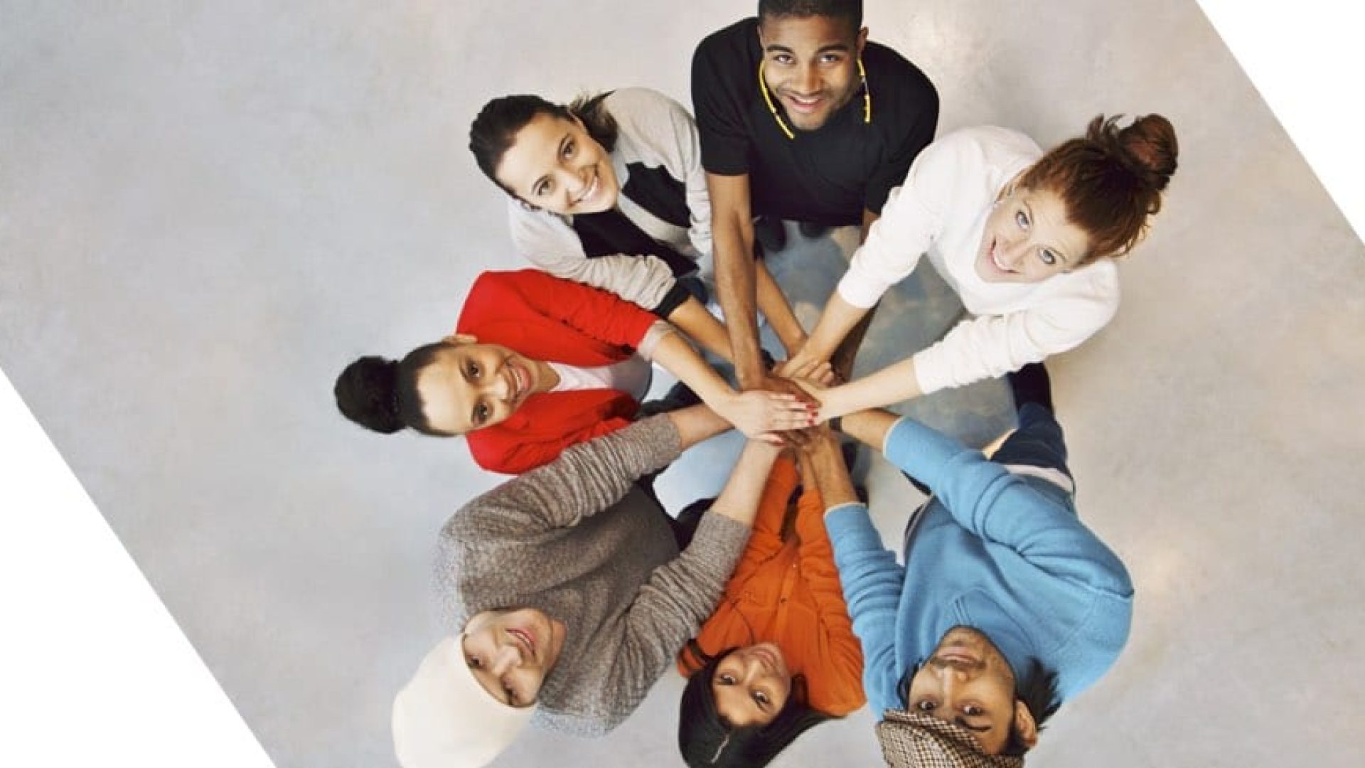 Multi ethnic group putting their hands together